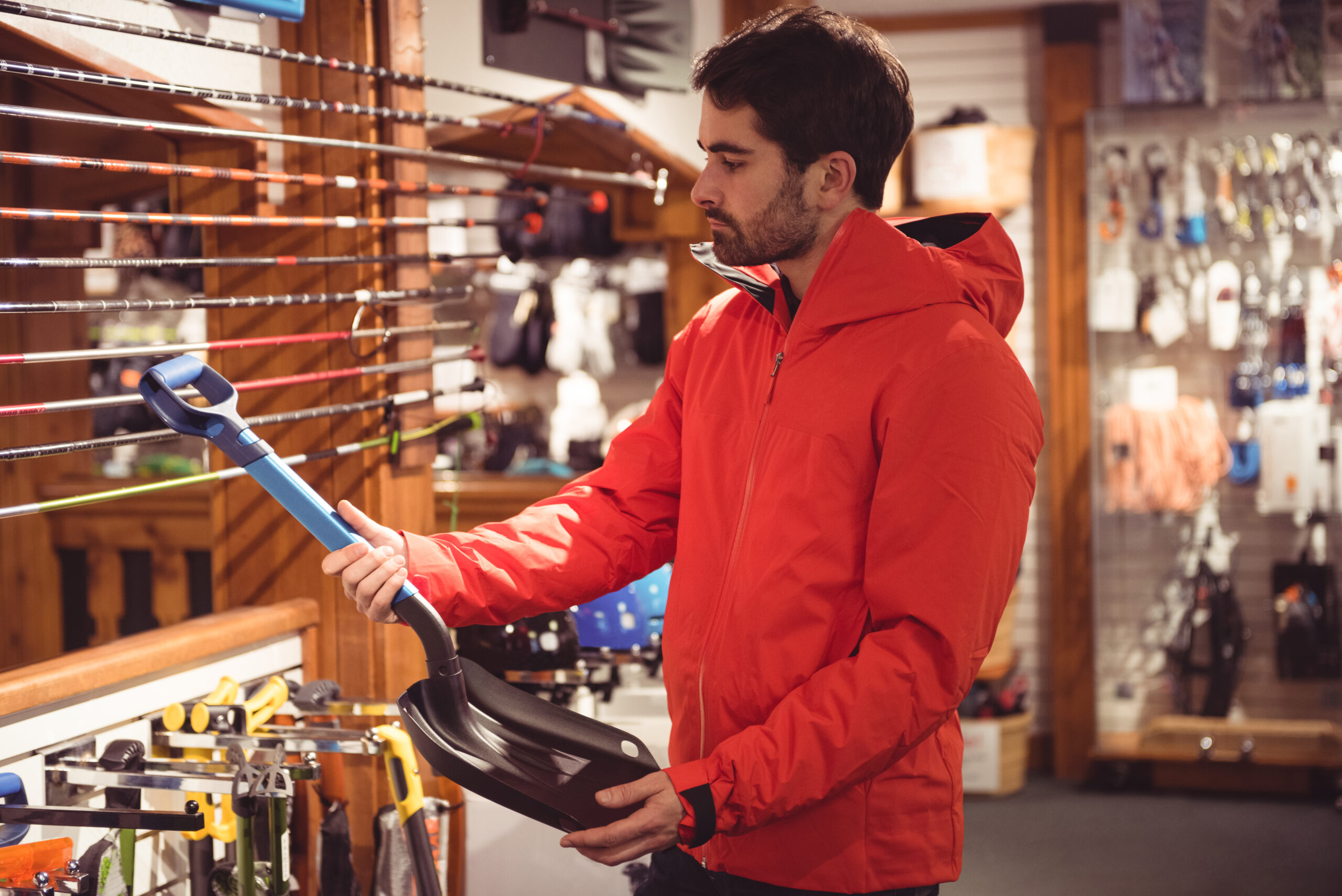 handsome man selecting shovel in a shop